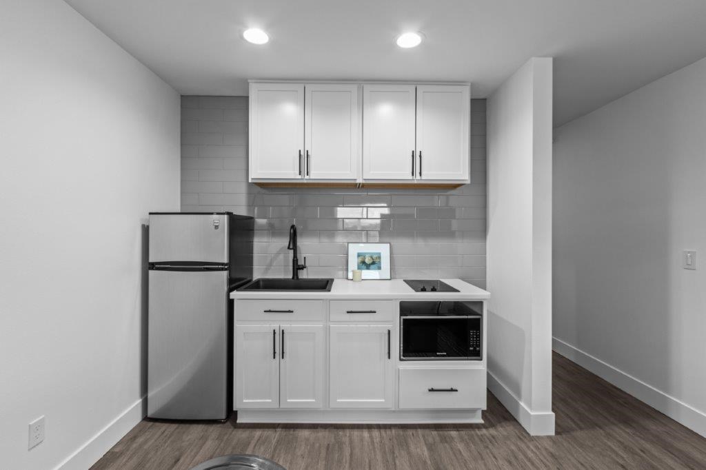 a kitchen with white cabinets and a refrigerator